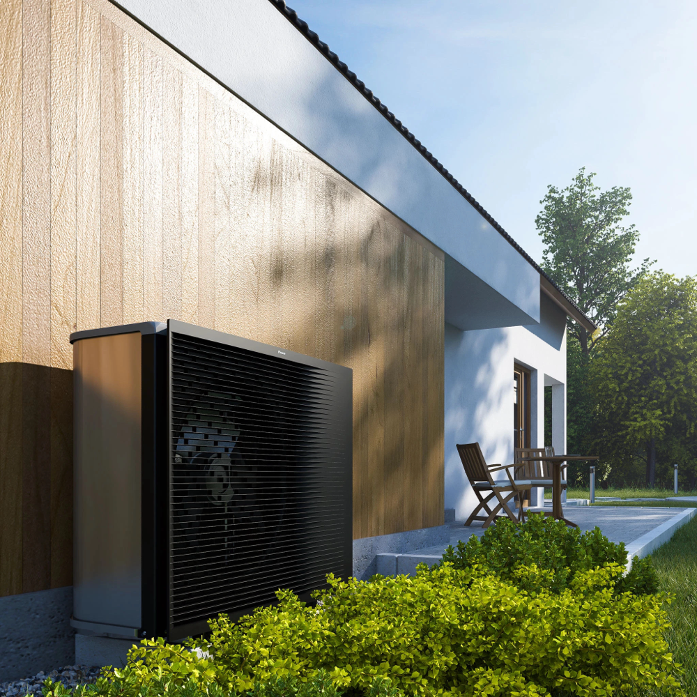 Schwarze Wärmepumpen-Außeneinheit an einer Holzfassade