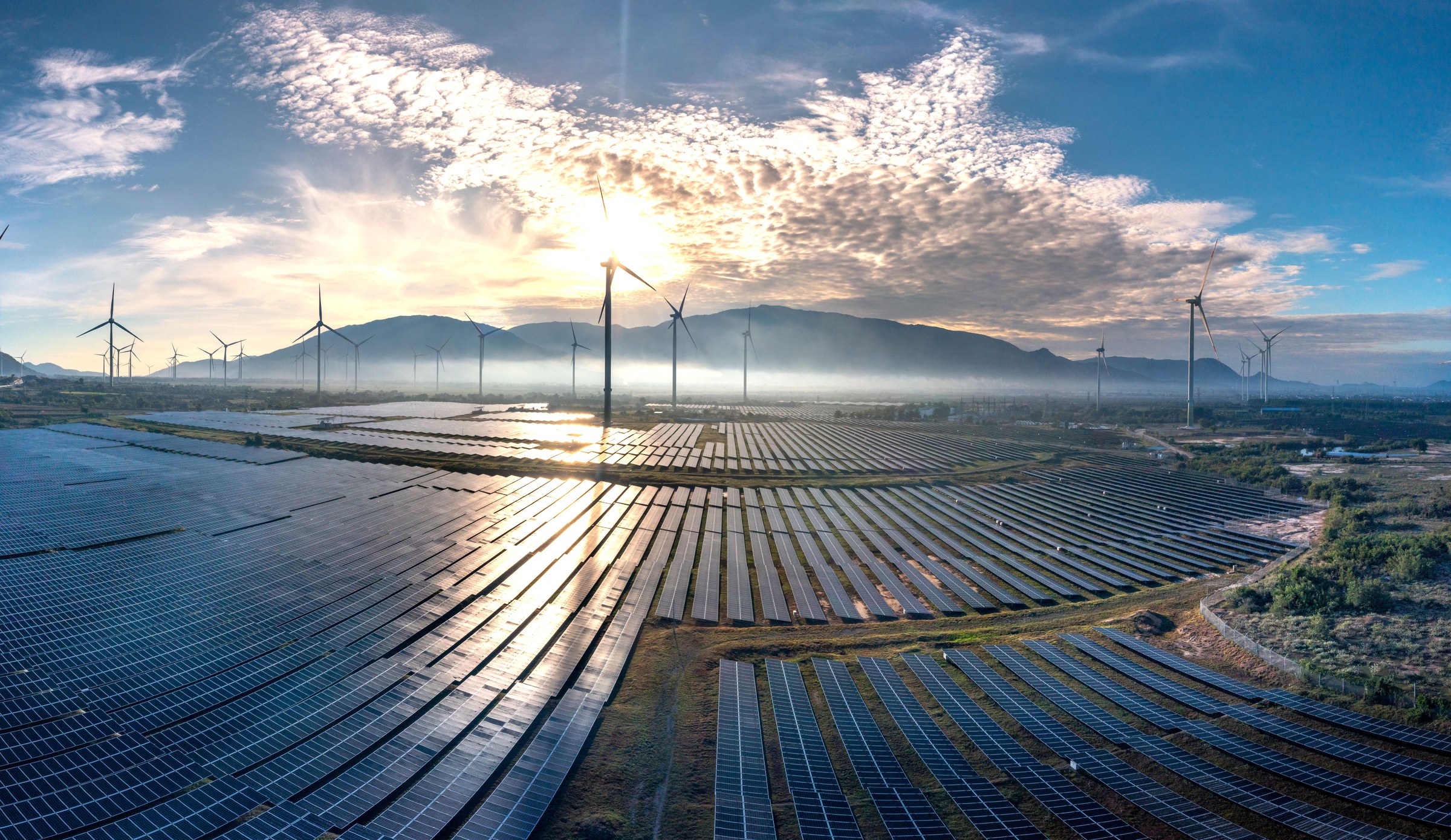 Luftaufnahme eines großen Solarparks bei Sonnenaufgang